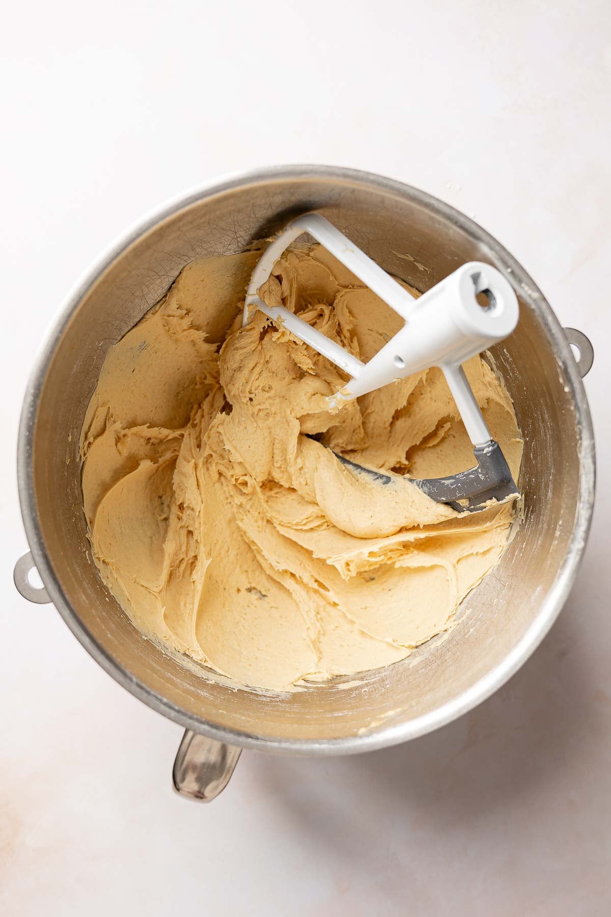 Gluten-free pumpkin bagel dough in mixer bowl.